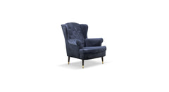 Stijlvolle fauteuil Caption in donkerblauw fluweel met een klassieke uitstraling. De stoel heeft een hoge, gewatteerde rugleuning met knoopdetails en gebogen armleuningen. Slanke zwarte poten met goudkleurige uiteinden voegen een verfijnde, moderne touch toe aan het tijdloze ontwerp.