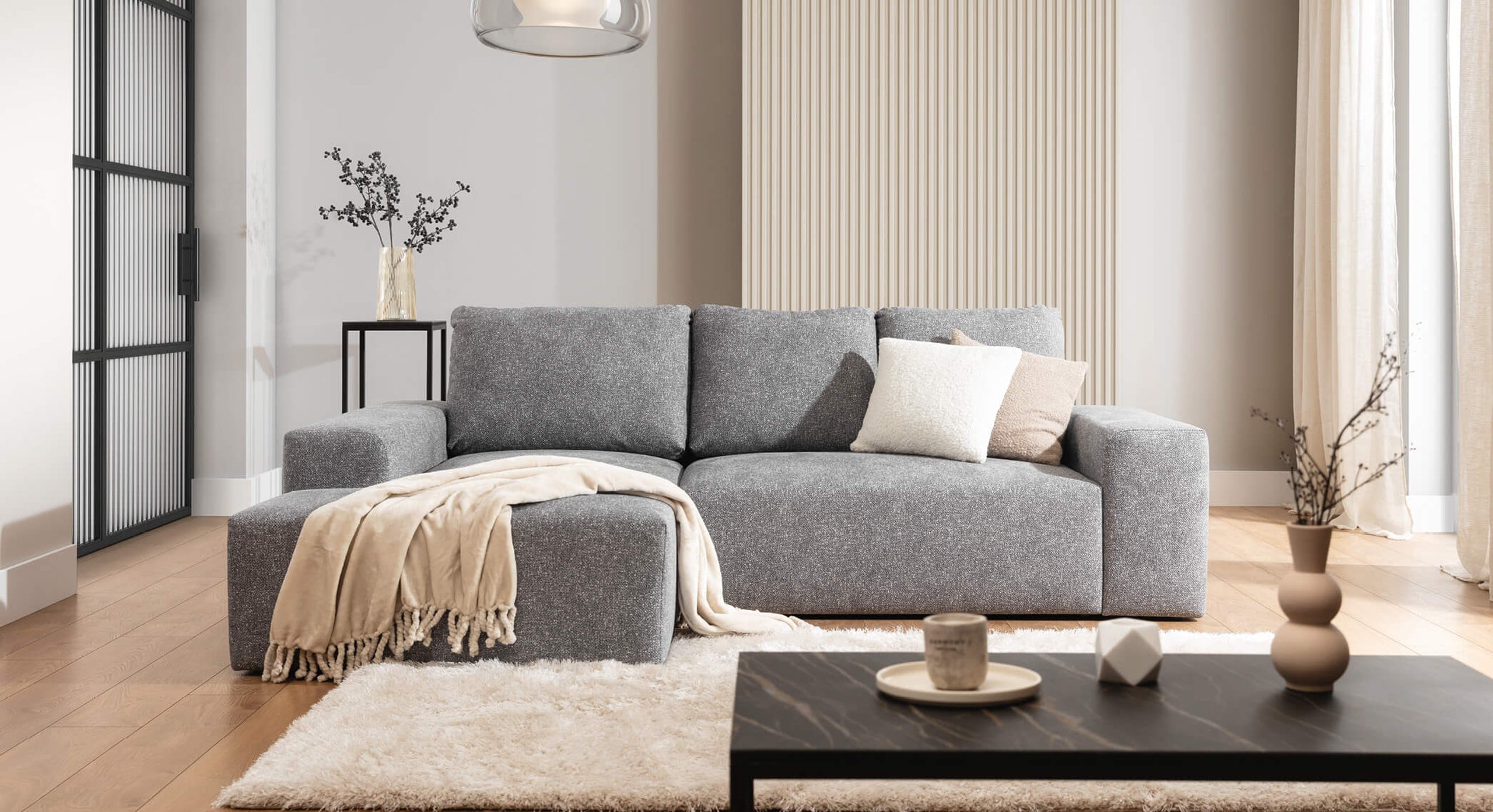 De Hoekbank Cosy Met Chaise Longue Links in een sfeervolle woonkameropstelling, aangekleed met lichte kussens en een beige plaid, perfect voor een warme en moderne inrichting.