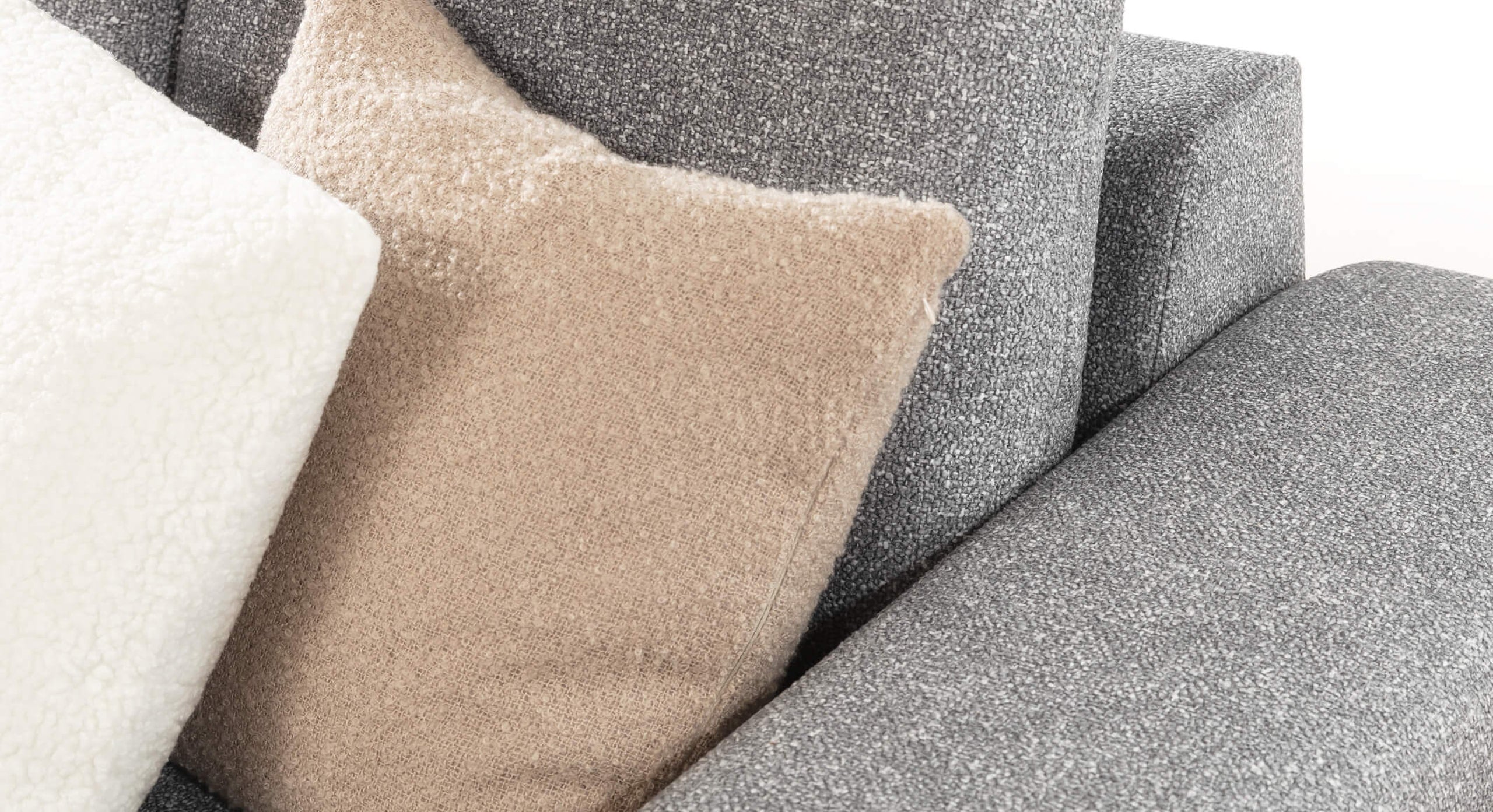 Close-up van de Hoekbank Cosy Met Chaise Longue Links met beige en witte kussens in zachte stoffen, die een comfortabele en stijlvolle uitstraling geven aan de bank.