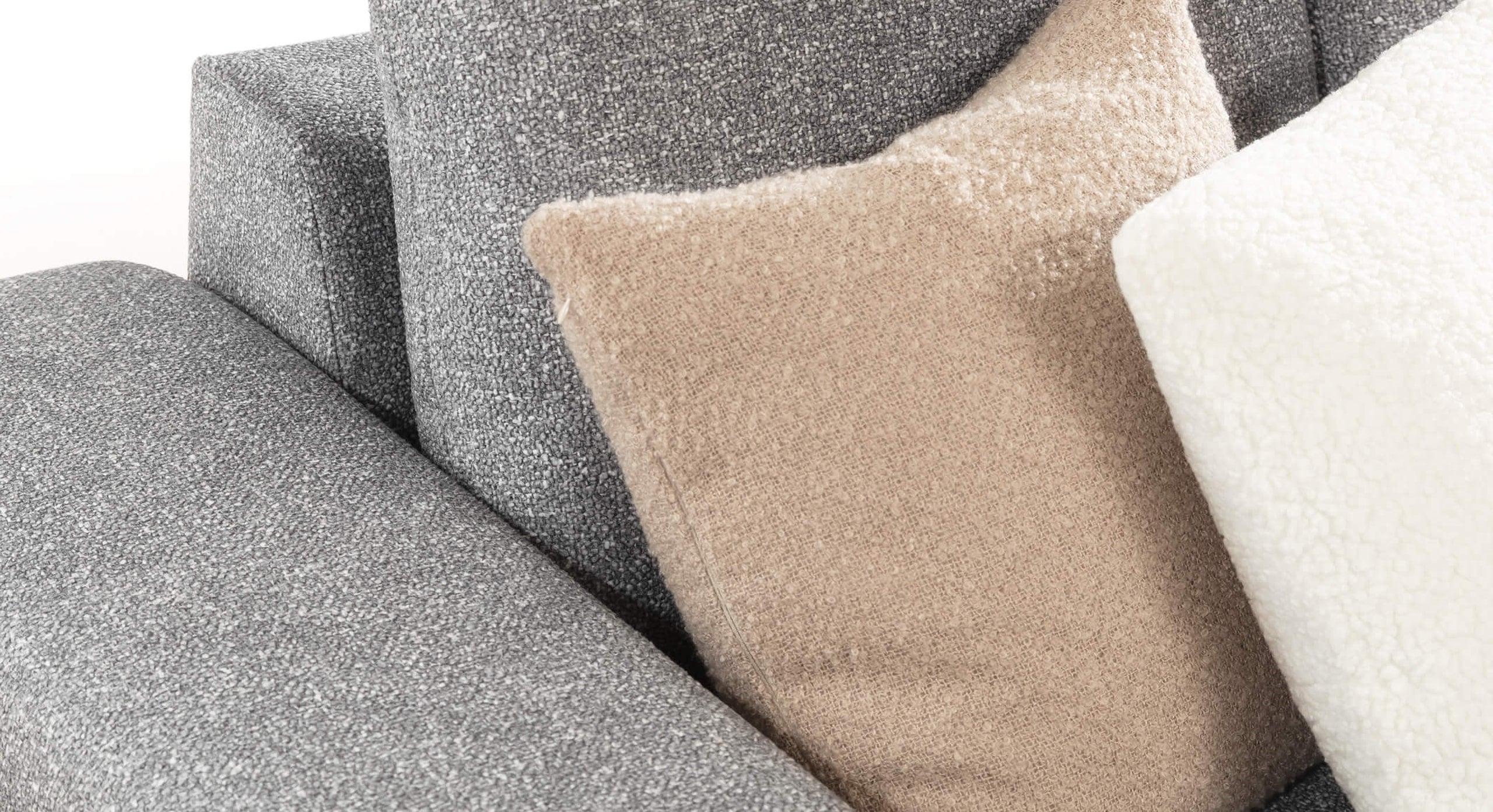 Close-up van de Hoekbank Cosy Met Chaise Longue Rechts met beige en witte kussens in zachte stoffen, die een comfortabele en moderne uitstraling geven aan de bank.