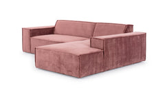 Schuin aanzicht van de Hoekbank Sense met chaise longue rechts, uitgevoerd in een warme roze stof. De bank heeft een minimalistisch design met brede armleuningen en strakke lijnen, wat een moderne en stijlvolle uitstraling geeft, ideaal voor eigentijdse interieurs.