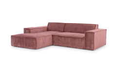 Hoekbank Sense met chaise longue links in een warme roze stof, met een minimalistisch design en brede armleuningen. De bank heeft een strakke en moderne uitstraling, ideaal voor eigentijdse interieurs die een vleugje kleur en comfort zoeken.